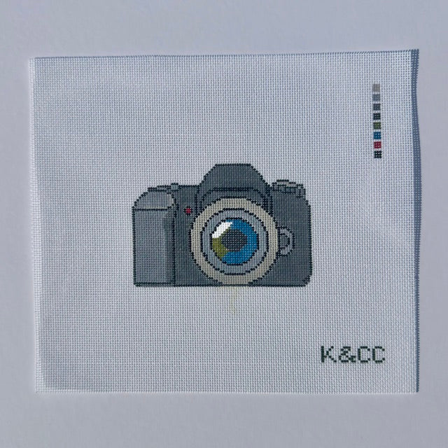 Hand painted needlepoint canvas depicting a camera on 18 mesh 